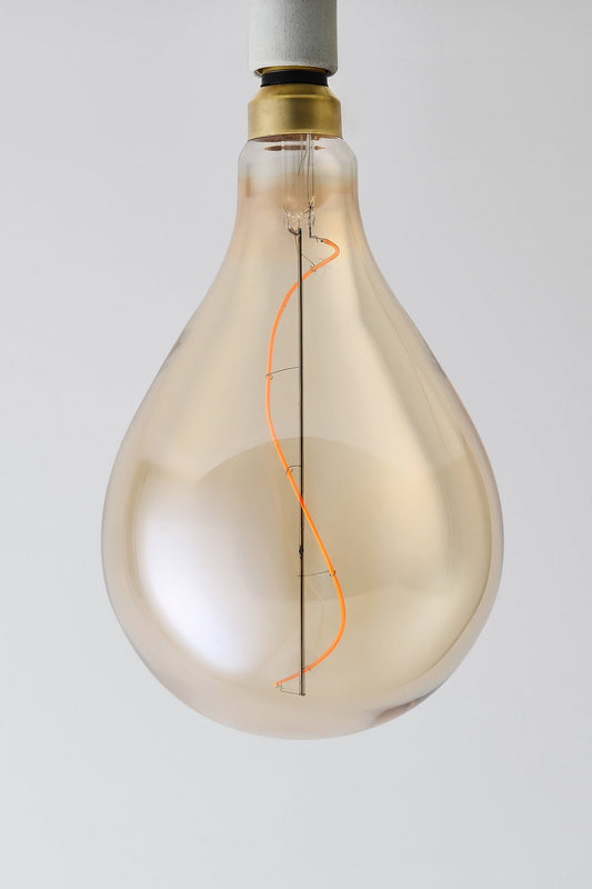 Modern teardrop LED light bulb with warm vintage Edison style glow