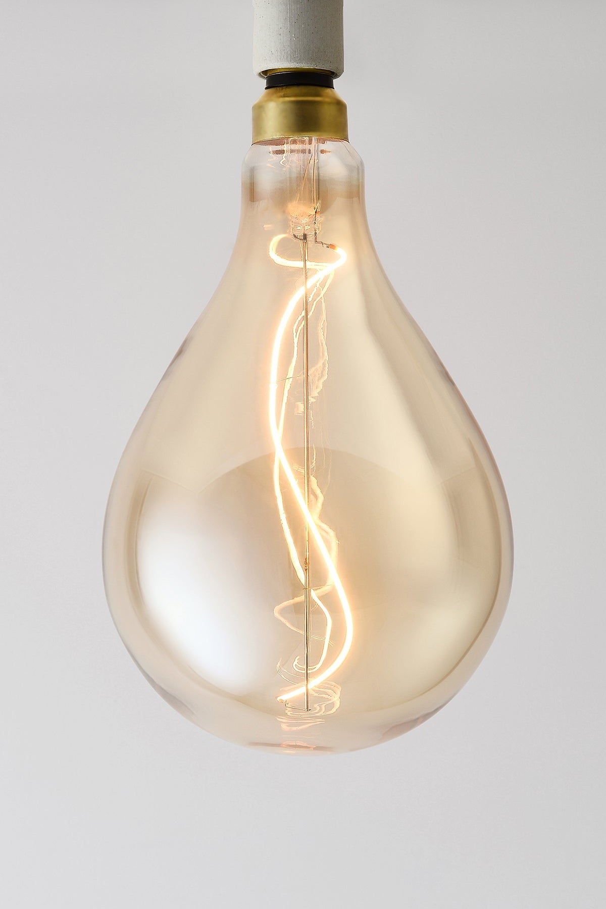 Modern teardrop LED light bulb with warm vintage Edison style glow