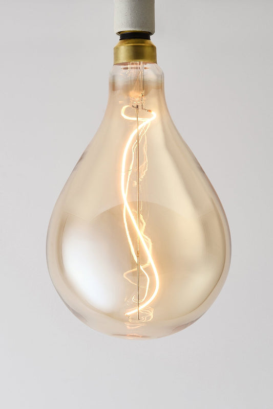 Modern teardrop LED light bulb with warm vintage Edison style glow