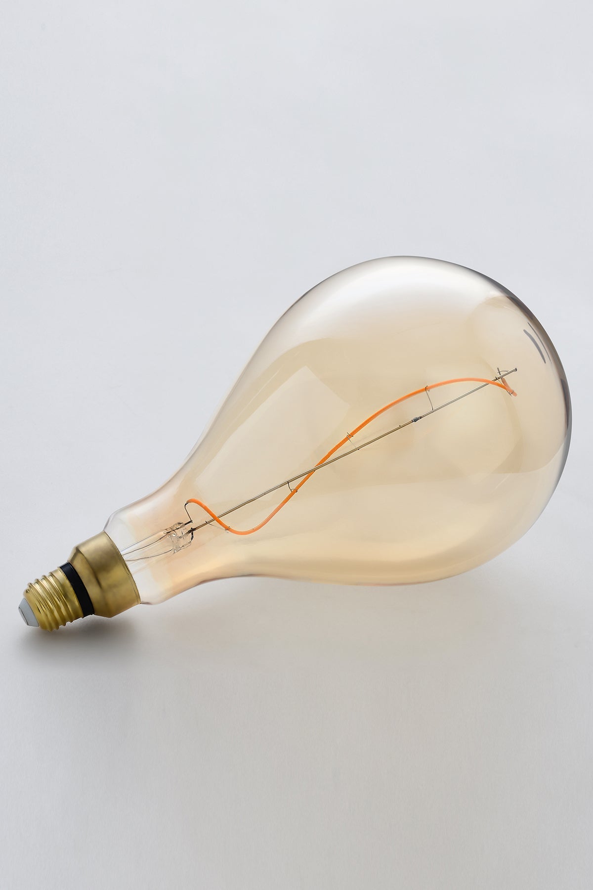 Modern teardrop LED light bulb with warm vintage Edison style glow