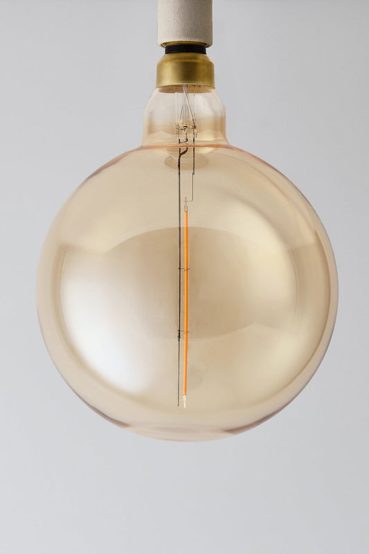 Modern globe LED light bulb with warm vintage Edison style glow