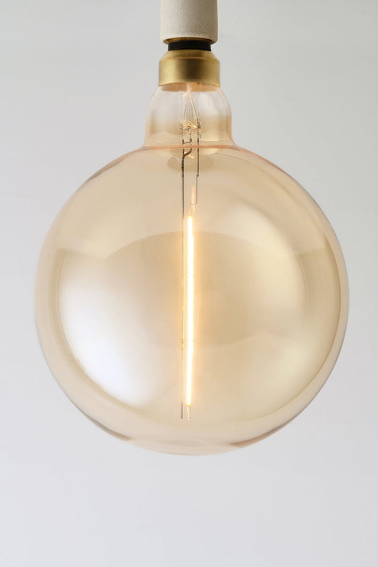 Modern globe LED light bulb with warm vintage Edison style glow