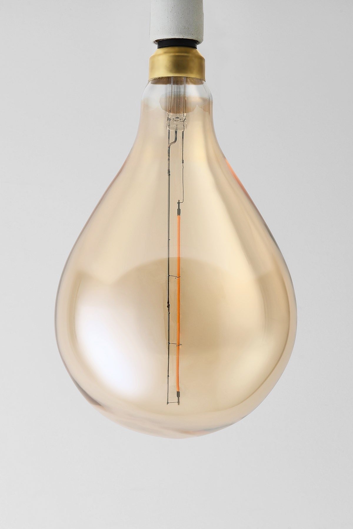 Modern teardrop LED light bulb with warm vintage Edison style glow