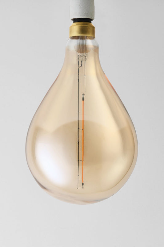 Modern teardrop LED light bulb with warm vintage Edison style glow