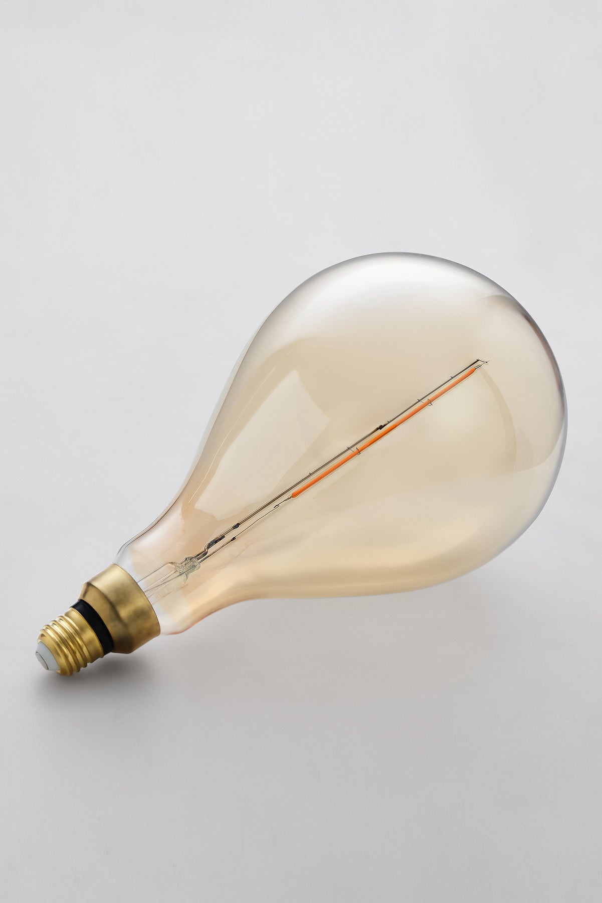 Modern teardrop LED light bulb with warm vintage Edison style glow