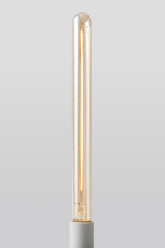 Close-up of Goldenline T8 LED bulb featuring warm amber glass and vintage-style filament for RH Edison Grand Sconce on a light grey background