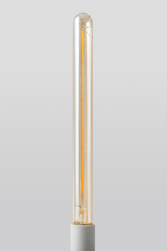 Close-up of Goldenline T8 LED bulb featuring warm amber glass and vintage-style filament for RH Edison Grand Sconce on a light grey background