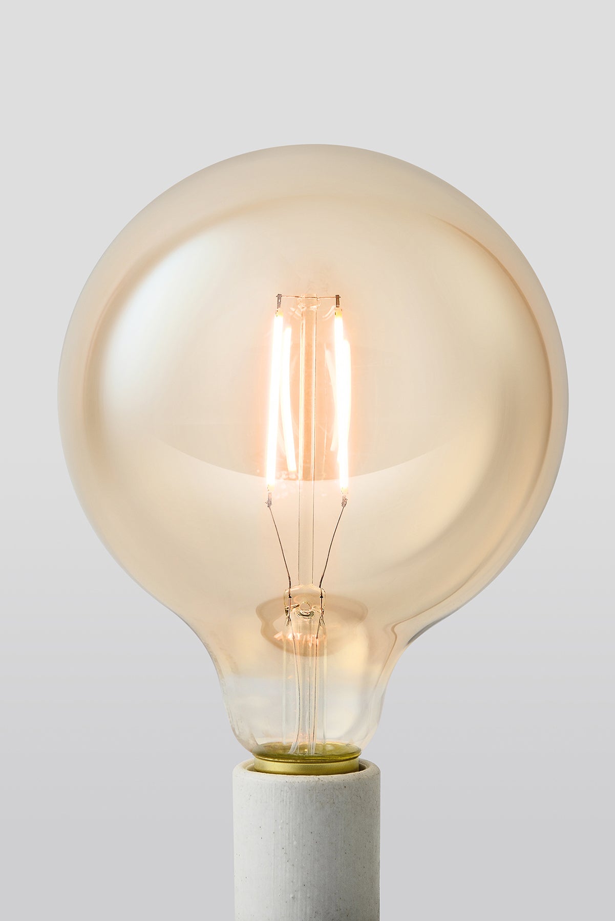 Modern G40 LED light bulb with warm vintage Edison style glow