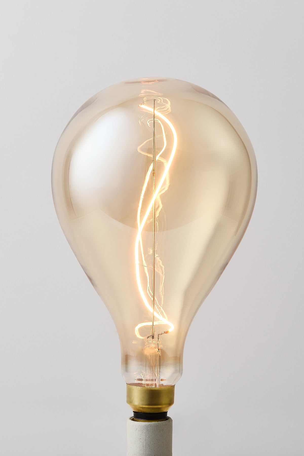 Modern teardrop LED light bulb with warm vintage Edison style glow
